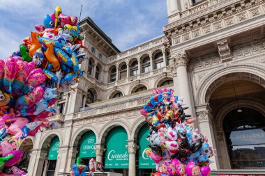 Milan, İtalya - Şubat 2023: Balon ve konfetiyle güneşli bir bahar gününde Milano 'daki Piazza Duomo Karnaval kutlamaları sırasında karnaval gibi giyinmiş kalabalık
