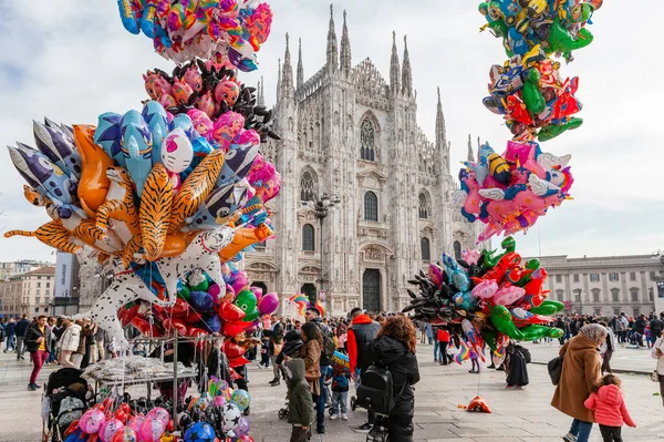 Milan, İtalya - Şubat 2023: Balon ve konfetiyle güneşli bir bahar gününde Milano 'daki Piazza Duomo Karnaval kutlamaları sırasında karnaval gibi giyinmiş kalabalık