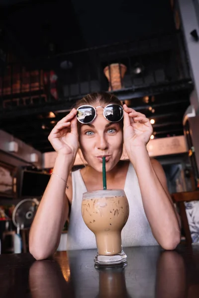 Pionowe Zdjęcie Zabawnej Kobiety Pijącej Mrożoną Kawę Słomką — Zdjęcie stockowe