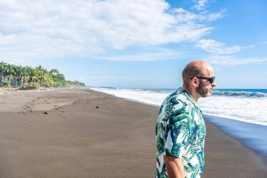 Hawaii gömlekli bir adamın tropik bir plaj boyunca yürüdüğü fotokopi odası.