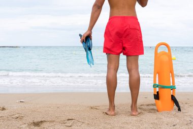 Sahilde görev yapan bir cankurtaranın bacaklarının kesilmiş fotoğrafı.