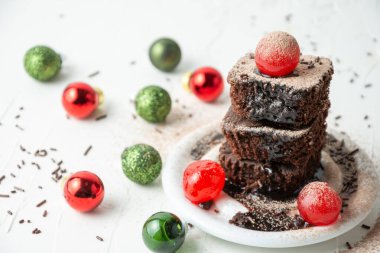 Kırmızı kirazlı browninin üst görüntüsü, noel topları, seçici odak, beyaz masa, yatay, kopyalama alanı