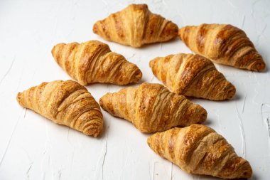 Overhead view of croissants on white table, selective focus, horizontal, with copy space