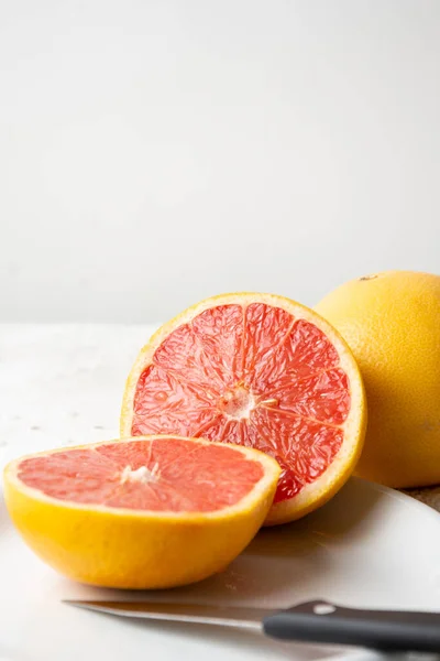 Nahaufnahme Von Gespaltener Roter Grapefruit Mit Einem Ganzen Auf Teller — Stockfoto