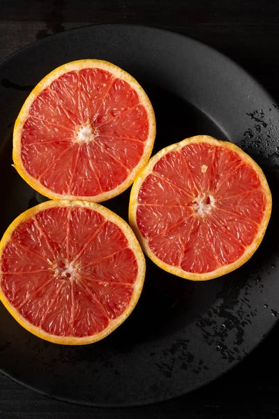 Overhead View Cut Red Grapefruits Plate Black Cloth Vertical Copy — Stock Photo, Image