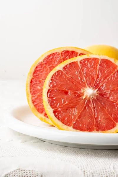 View of cut red grapefruit with selective focus, white background, vertically, with copy space