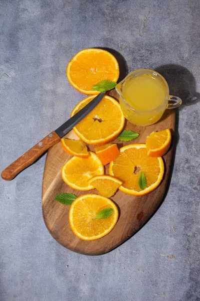 Masanın Üzerinde Portakal Dilimleri Meyve Suyu Bıçak Ile Gri Arkaplan — Stok fotoğraf