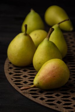 Tahta masadaki yeşil armutların üst görünümü, seçici odak, siyah arkaplan, dikey, kopyalama alanı ile