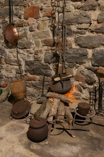 Katalan taşından bir çiftlik evi manzarası. Geleneksel bir ateş, çömlekler, dikey.