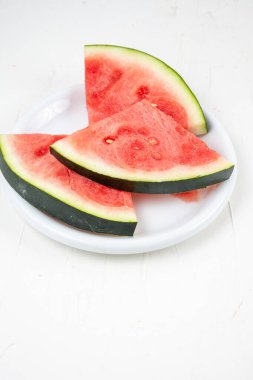 Tabaktaki karpuz dilimlerinin üst görünümü ve beyaz arkaplan, dikey, kopyalama alanı ile