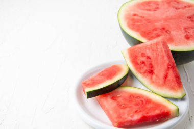 Tabakta kırmızı karpuz dilimlerinin üst görünümü ve beyaz arkaplan, yatay, kopyalama alanı ile