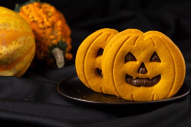 Balkabağı ve çikolatalı kurabiyeleri siyah tabakta görmek, balkabakları, siyah arka plan, yatay, kopyalama alanı ile