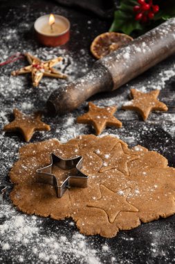 Un, merdane ve portakallı ahşap masanın üzerinde yıldızlı zencefilli kurabiye hamurunun havadan görünüşü