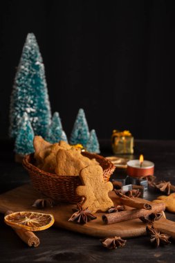 Üzerinde tarçın, yıldız anason, turuncu ve Noel ağaçları olan sepetli sepetin üst görüntüsü, dikey, fotokopi alanı ile