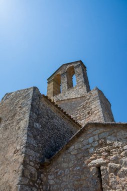 Kale kilise kulesinin alçak açılı görüntüsü, Olerdola, İspanya, Avrupa, 8 Ağustos 2024, dikey