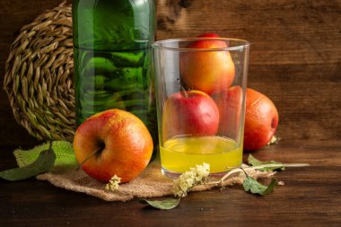 Elmalı ahşap arkaplan ve elmalı doğal elma şarabı ile yakın plan, kopyalama alanı ile yatay