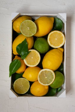 Limonlu, limonlu ve yeşil yapraklı beyaz kutunun hava görüntüsü, beyaz arkaplan, dikey, kopyalama alanı ile