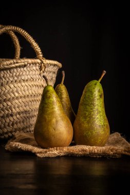 Masadaki üç armutun görüntüsü, siyah arkaplan, dikey, kopyalama alanı olan