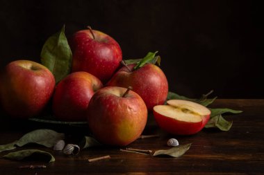 Masadaki kırmızı elma ve kurumuş yaprakların yakın plan, koyu arkaplan, yatay, kopyalama alanı olan