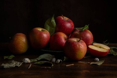 Bir masadaki kırmızı elma ve kurumuş yaprakların görüntüsü, siyah arkaplan, yatay, kopyalama alanı olan