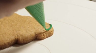 Pasta şefi yeni yılın zencefilli kurabiyelerini renkli jölelerle süslüyor.