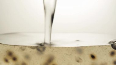 Fesleğenli beyaz köpüklü içecek, bardakta küçük gaz kabarcıkları. Makro video.