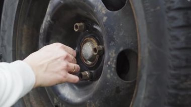 Manikürlü bir kız araba tekerleği, kriko, ingiliz anahtarı, yağ değiştirir. yakın plan.