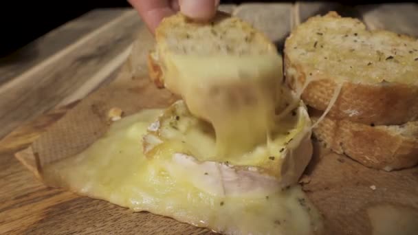 溶かしたカマンベールチーズにバゲットを浸し — ストック動画