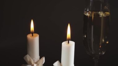 Şampanya ve alyanslı iki beyaz düğün mumu. Kaydırak atışı, yakın plan..