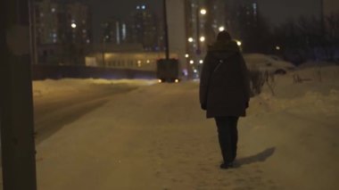 Karlı bir gece sokağında, arabalı bir kızı gözetlemek. Gece şehri