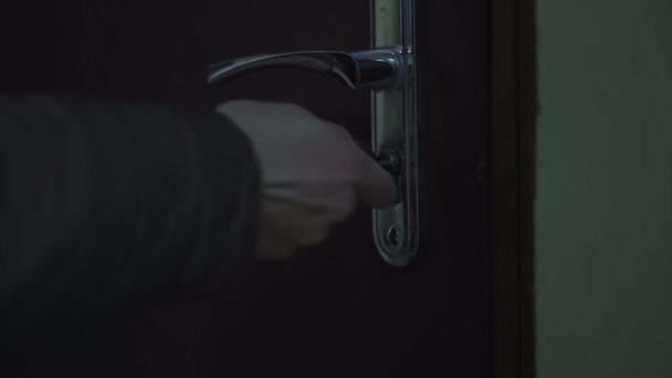 暗い入り口で鍵を持って家の前のドアを開けて — ストック動画