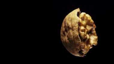 Siyah arka planda yarım ceviz kırılması dönüşümlü. Yakın plan..