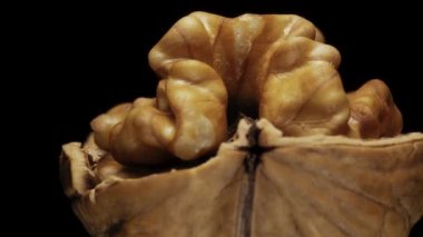 Siyah arka planda yarım ceviz kırılması dönüşümlü. Makro.