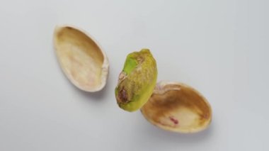 Soyulmuş fıstık. Kabuğun etrafında dönüyormuş. Yakın plan. Beyaz arka plan. Yukarıdan görüntüle.