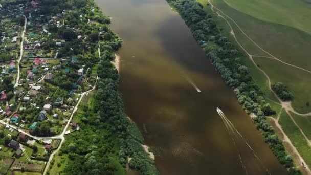 ドローンだ 川の上を飛ぶ 田舎の家 ボートは川に沿って航行する 人々は泳いでいる — ストック動画