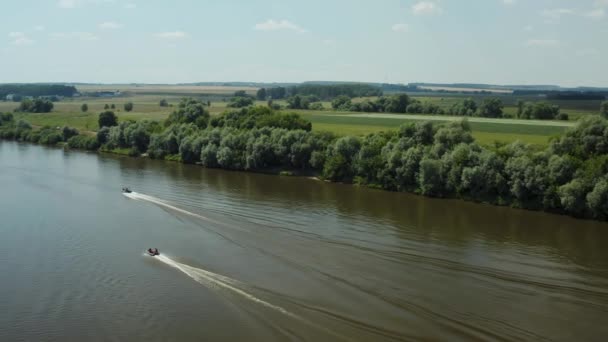 ドローンだ 川の上を飛ぶ 田舎の家 ボートは川に沿って航行する 人々は泳いでいる ボートの後ろに飛び — ストック動画