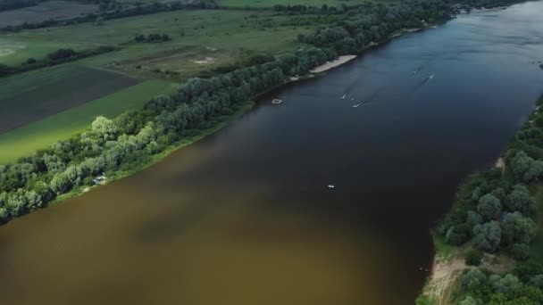 无人机 飞过河 乡村住宅 小船沿河航行 人们在游泳 — 图库视频影像