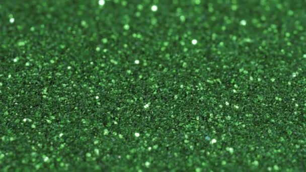 マクロスライドショット 小さな緑のスパンコール 光の中でシマー — ストック動画