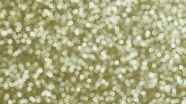 Altın bokeh. Parlak toplara yaklaşmanın ve onları bulanıklaştırmanın etkisi. Odaklanamayan tatil ışıkları. Parıltı