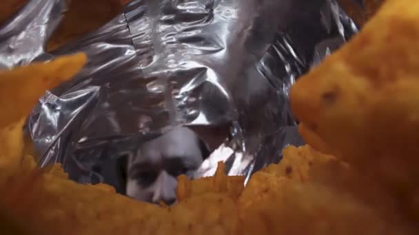 Een Man Opent Een Zak Chips Kijkt Naar Binnen Camera — Stockvideo