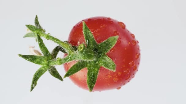 有绿叶和花朵的心形小西红柿 旋转着 在一个白色的背景特写 从上面看 — 图库视频影像