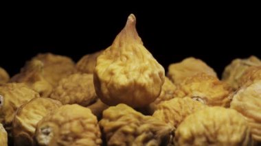 Kurutulmuş incirler, siyah arka planda yakın plan çekimde döner. Hareket halinde