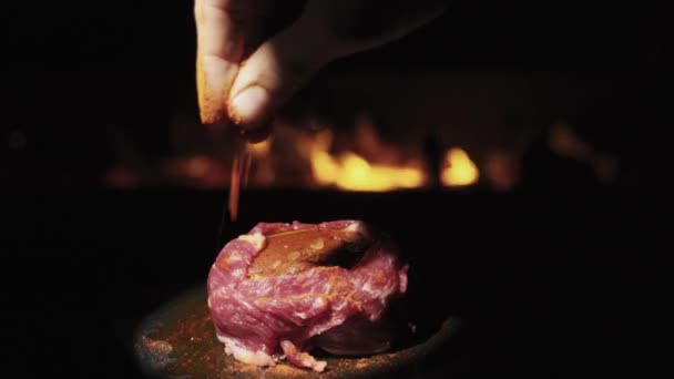 在火堆的背景下 一片牛肉可以烤成细条 旋转着 洒上红辣椒 — 图库视频影像