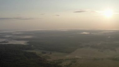 Drone video. Summer. Dawn with fog over the forest and lake.