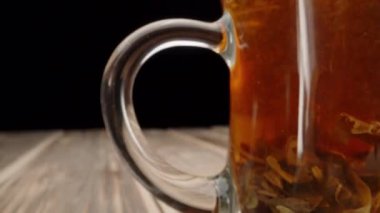 Honey flows onto pancakes, the camera flies through a mug of tea, close-up.