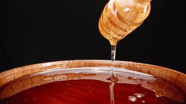 蜂蜜の木のプレート 蜂蜜は木製のスプーン スーパーマクロから排水します スローモーション — ストック動画