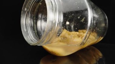 Macro video of a glass bottle, juice from apricots. Dolly slider inside apricot bottle close-up, rotation. Laowa Probe