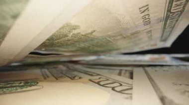 Pile of american dollars cash money, the camera slides under the dollars. Closeup new american one hundred dollar bills. Dolly slider. Laowa Probe