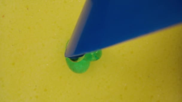 黄色いスポンジの上に洗剤を垂らします 内部のドリースライダーの極端なクローズアップ ラオワプローブ — ストック動画