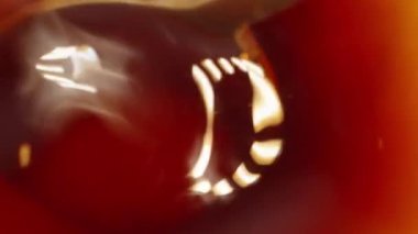 I stir sugar in tea with a spoon, top view. Dolly slider extreme close-up inside. Laowa Probe